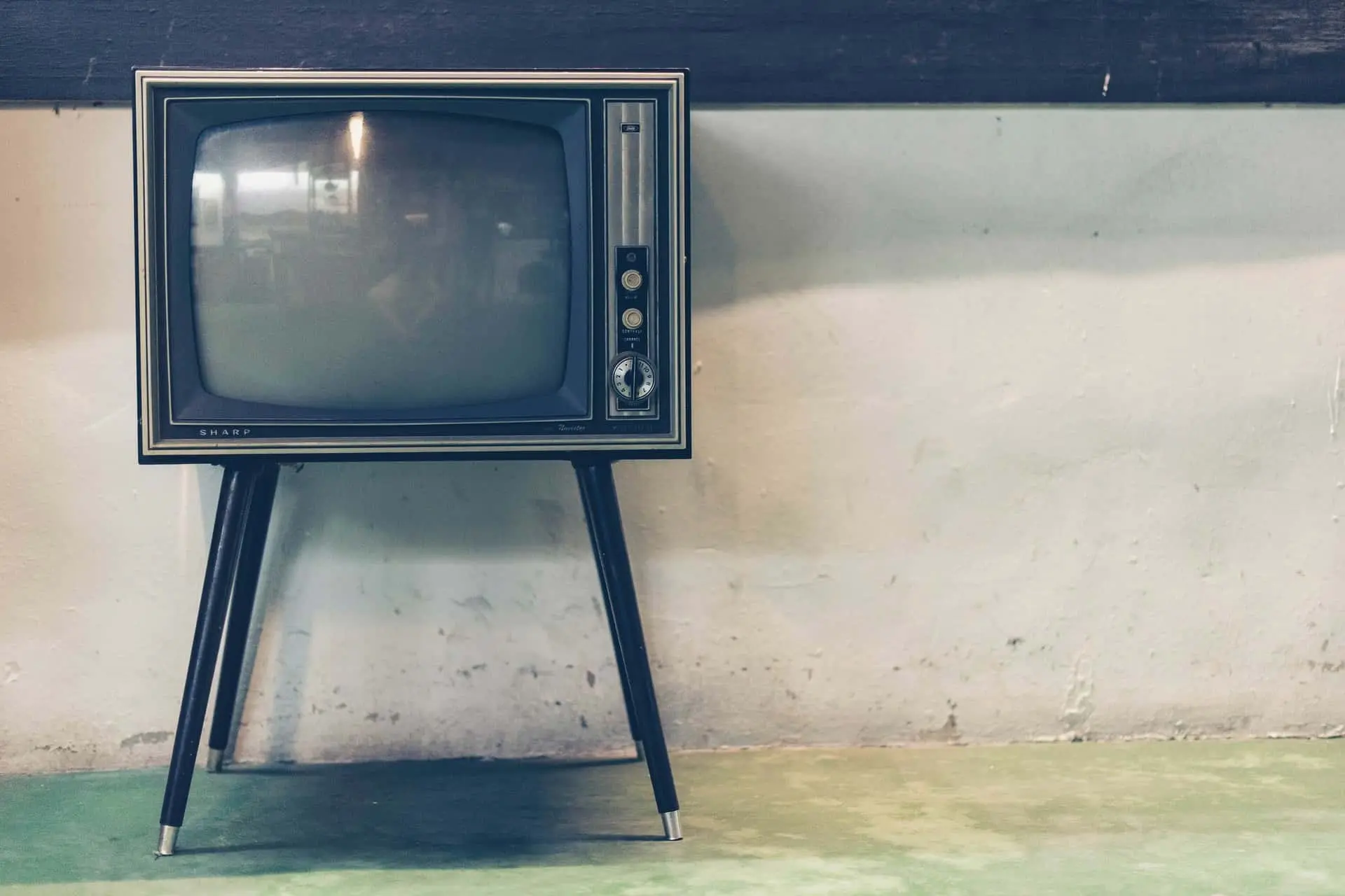 Téléviseur rétro Sharp sur pieds dans un intérieur ancien