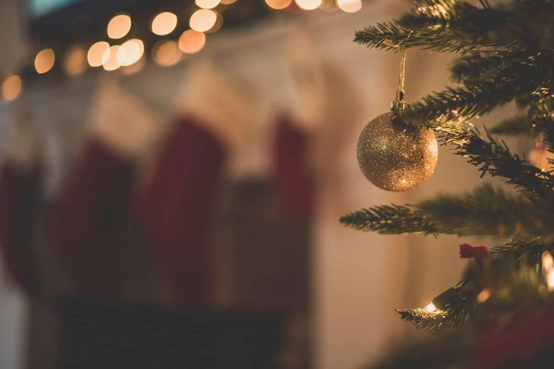 Boule de Noël dorée sur sapin flou