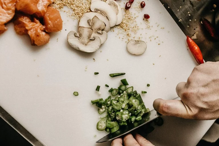 Préparation culinaire, découpe des légumes frais avec du saumon sur le côté