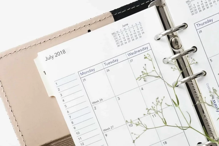 Agenda ouvert sur juin et juillet 2018 avec fleurs.