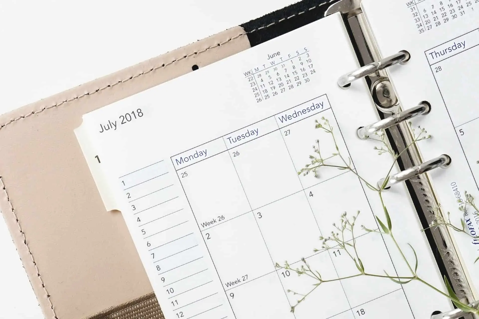 Agenda ouvert sur juin et juillet 2018 avec fleurs.