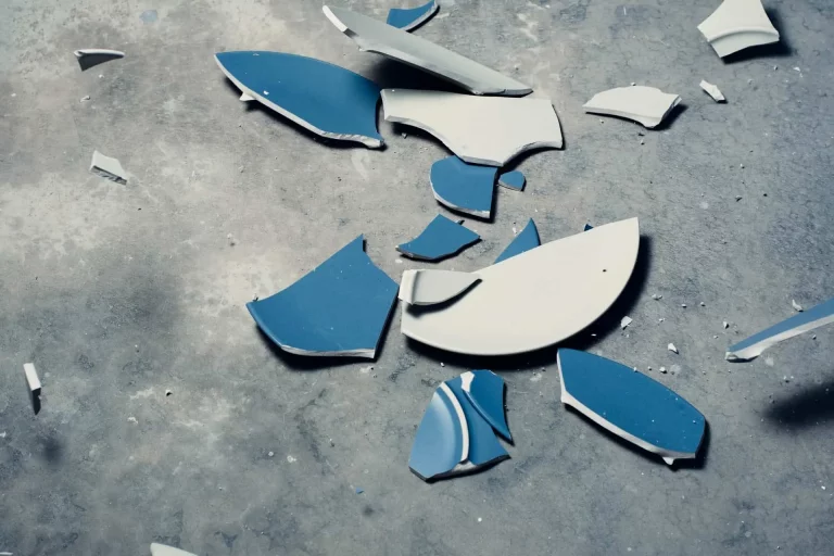 Assiettes bleues brisées sur sol en béton