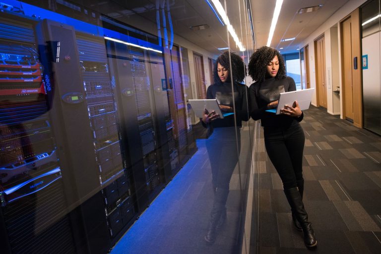 Femme ingénieure analyse avec son ordinateur en main des serveurs en datacenter