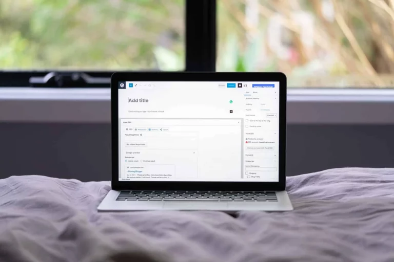 Ordinateur portable sur lit avec interface blog SEO ouverte