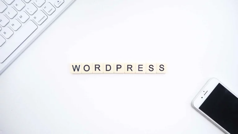 Lettres 'WORDPRESS' près d'un clavier et iPhone