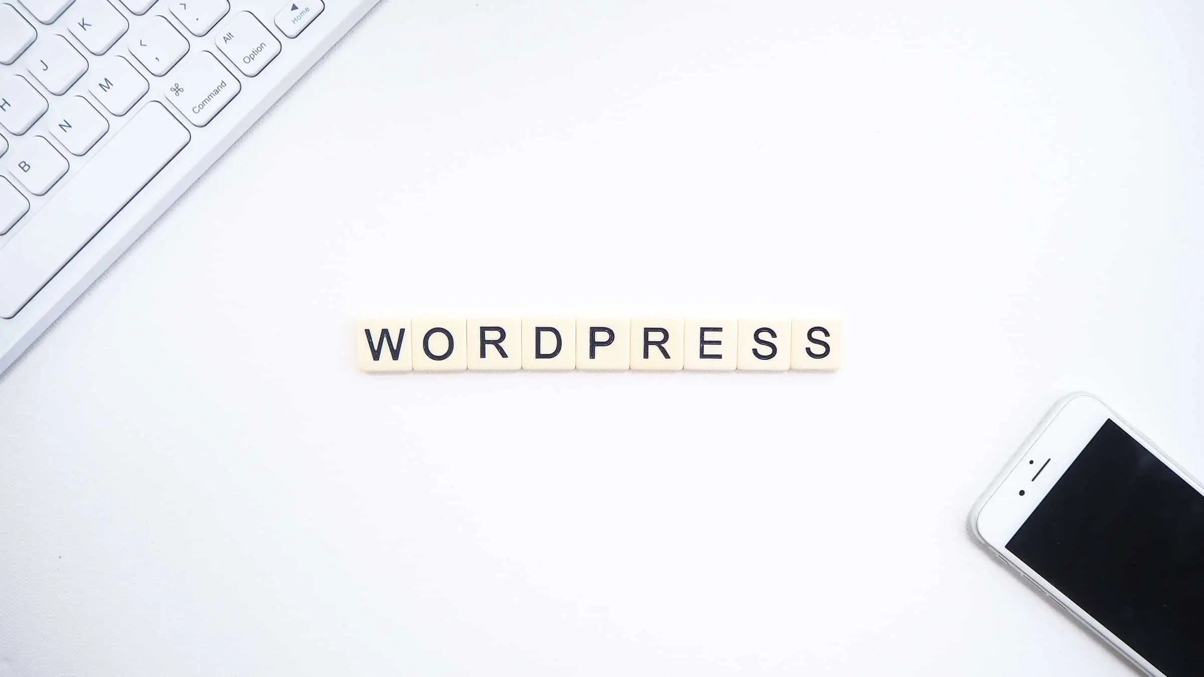 Lettres 'WORDPRESS' près d'un clavier et iPhone