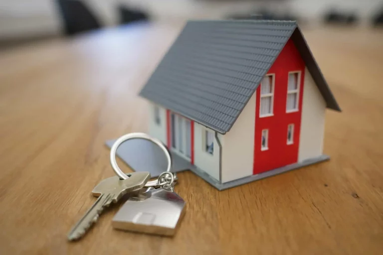 Maison miniature avec clés sur table en bois