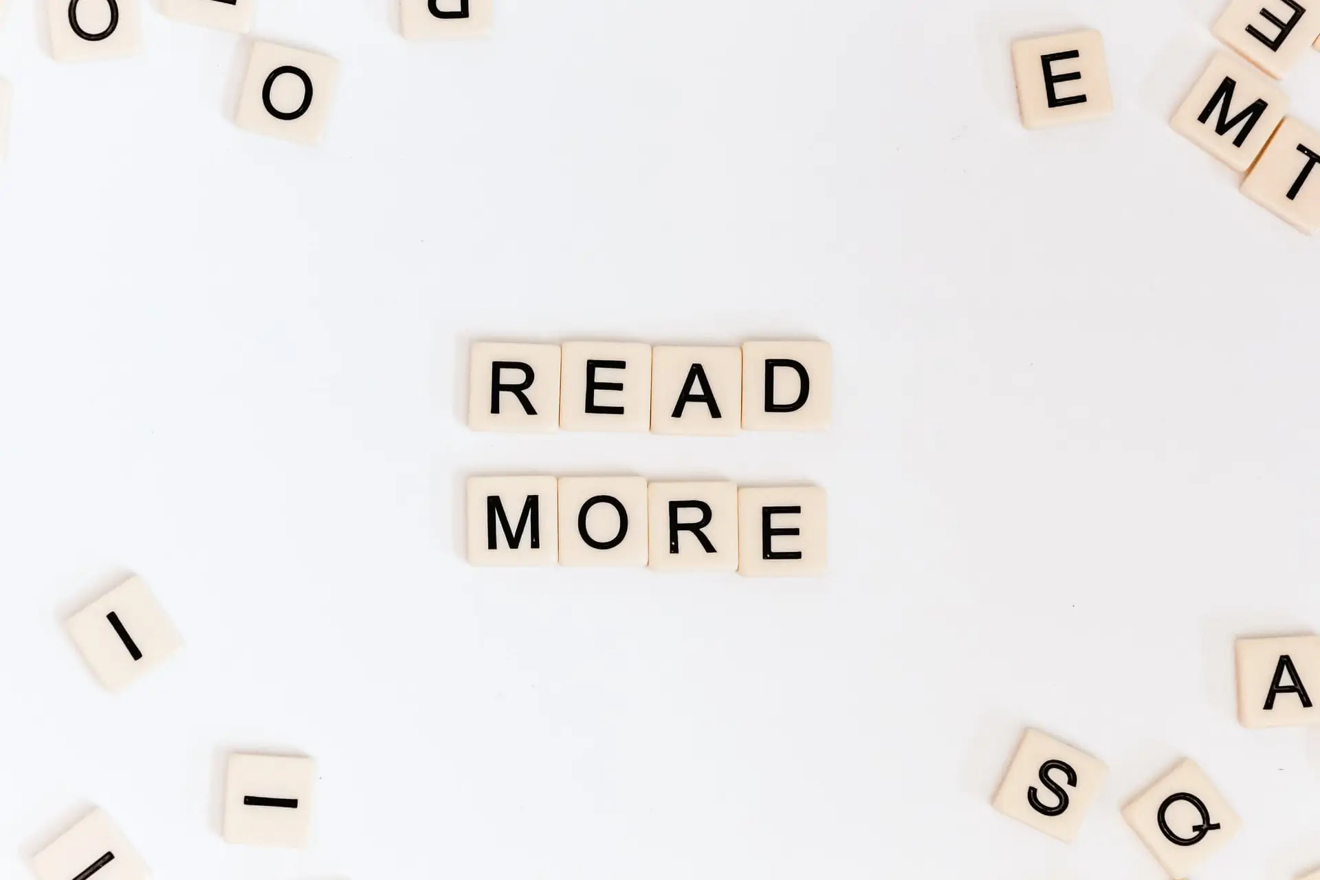 Mots 'LIRE PLUS' en anglais avec cubes lettres sur fond blanc