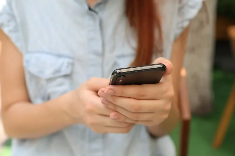 Femme rousse utilisant smartphone en extérieur