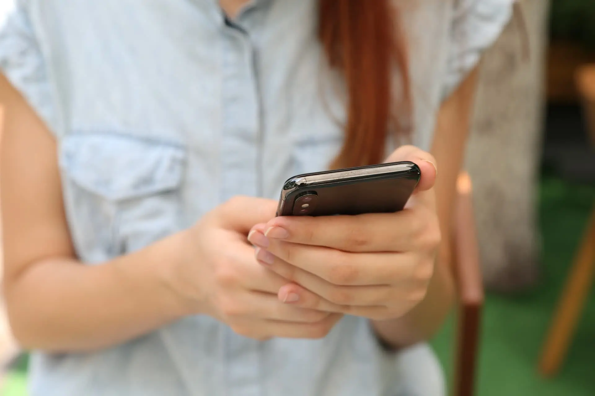 Femme rousse utilisant smartphone en extérieur