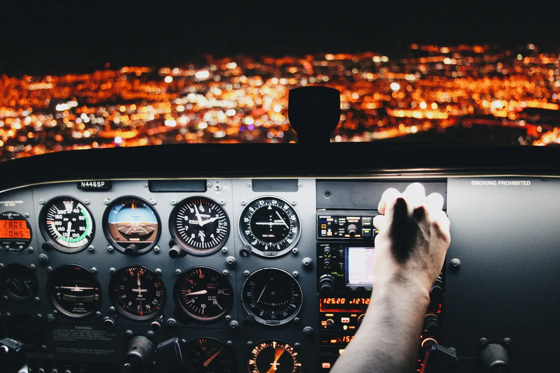 Vue cockpit avion nuit, lumières ville en fond