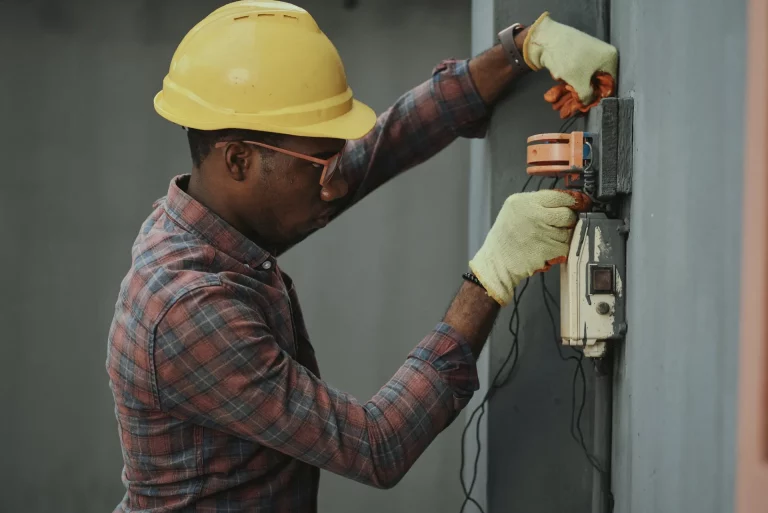 Électricien réparant un boîtier électrique