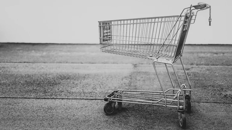 Caddie de supermarché vide sur terrain vide, noir et blanc