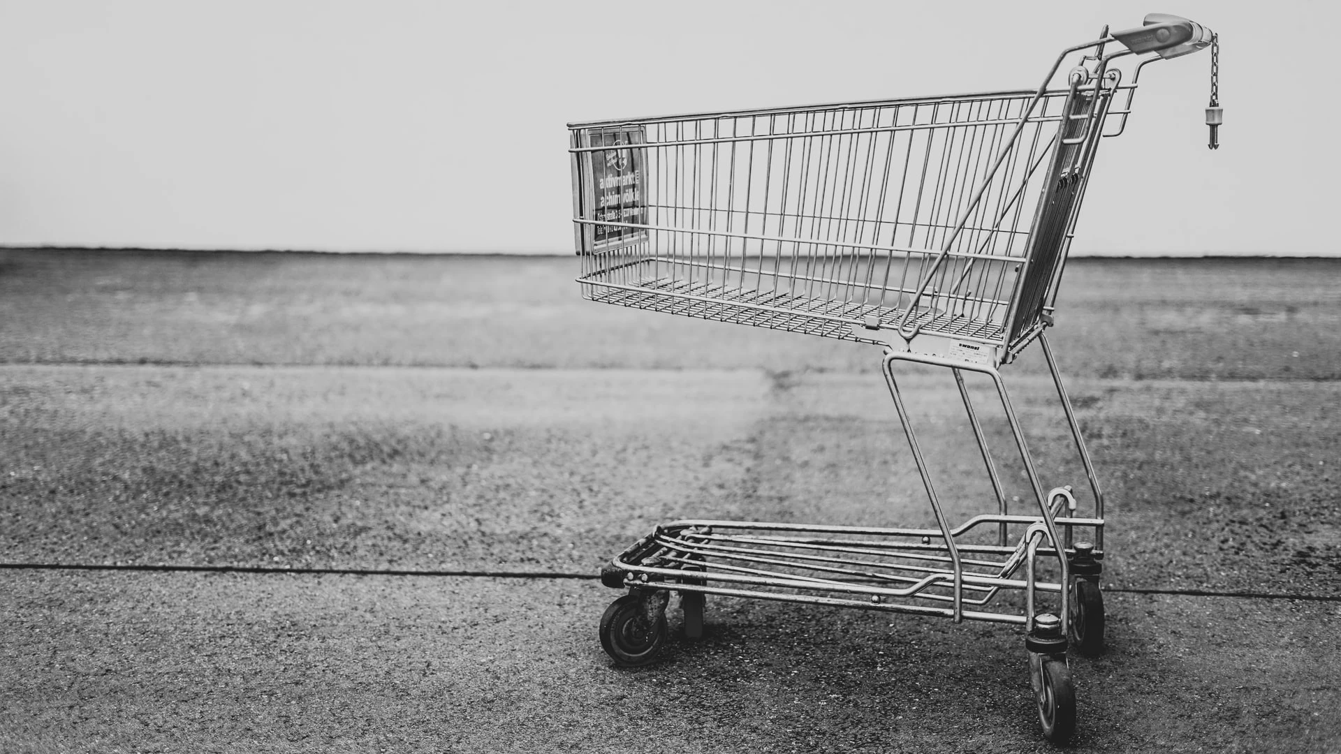 Caddie de supermarché vide sur terrain vide, noir et blanc