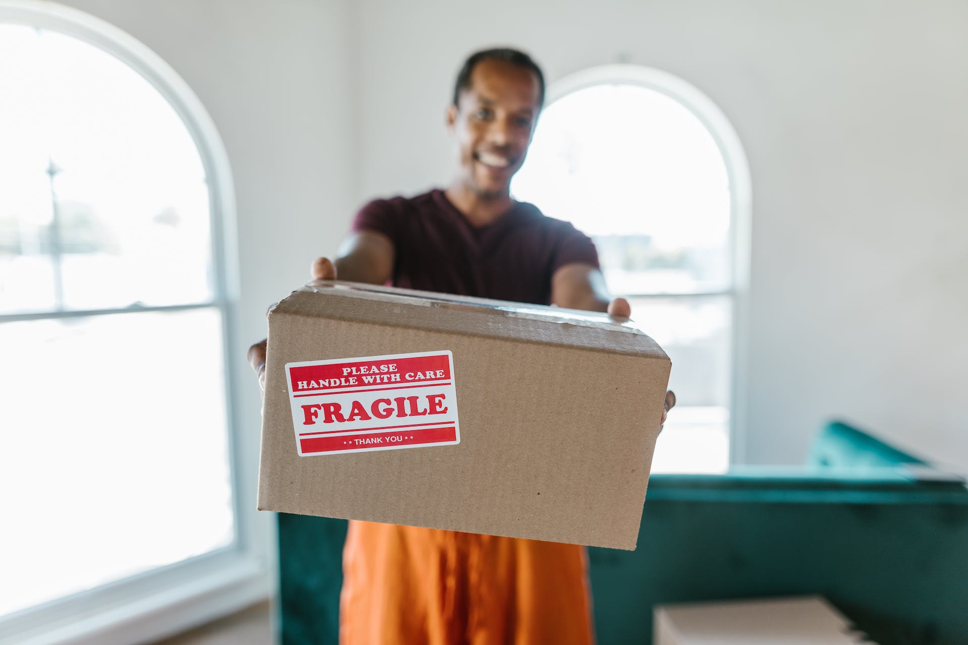 Homme remettant un colis fragile souriant