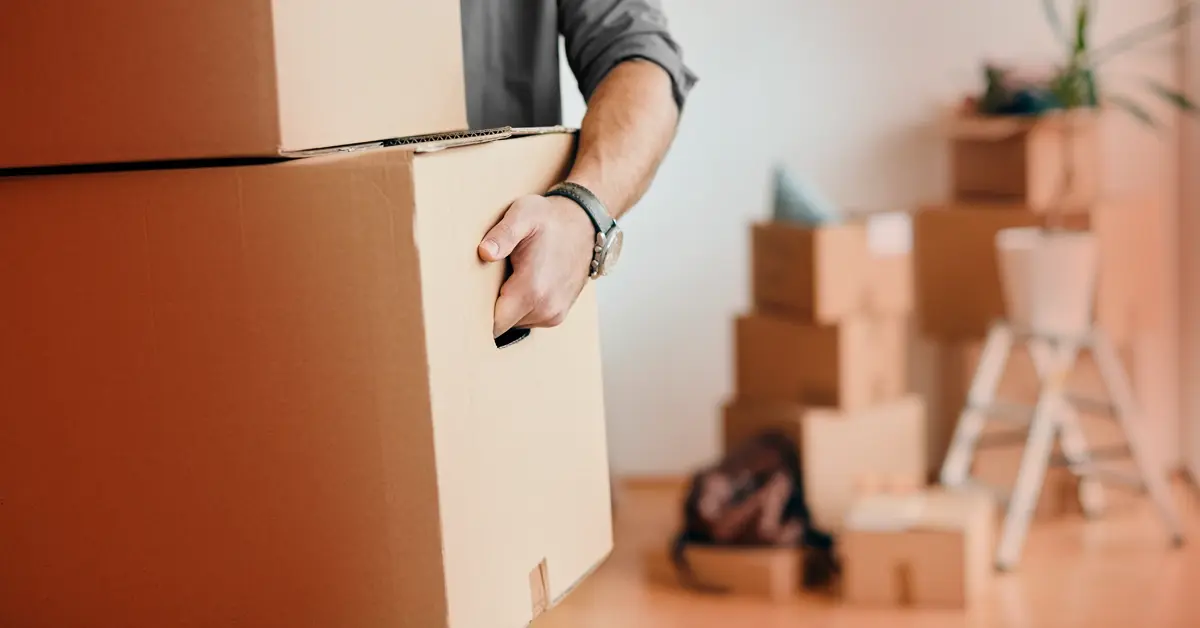 Homme déplaçant des cartons dans un nouvel appartement