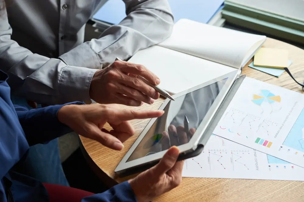 Homme analysant des données sur tablette et documents