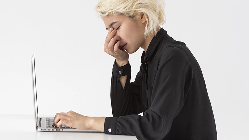 Personne fatiguée travaillant sur un ordinateur portable