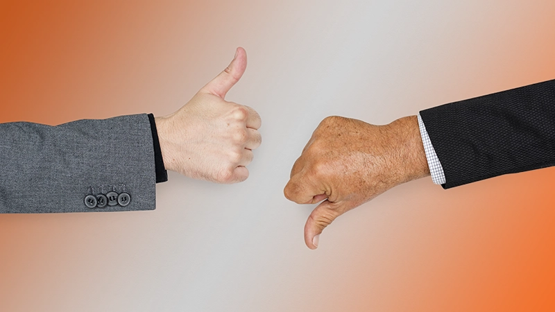 Deux mains d'hommes, l'une en face de l'autre. Une main avec le pouce levé, l'autre avec le pouce baissé, en signe de contraste.